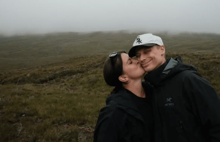 Näyttelijä Mimosa Willamo suutelee puolisoaan Ville Hilskaa poskelle parin yhteisellä retkellä luonnon keskellä.